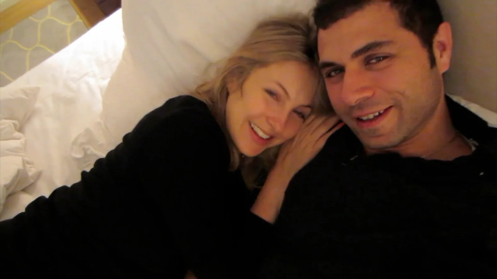 Claire Naber Matalqa and Amin Matalqa lying side by side, their heads touching as they smile at the camera.